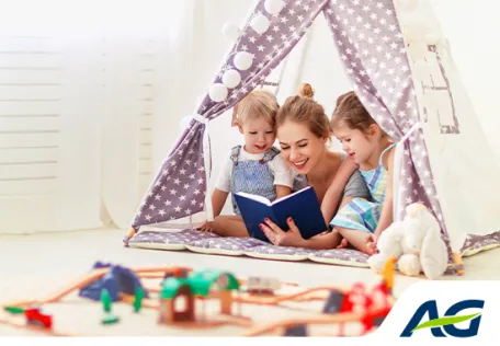 Moeder leest boek voor aan twee kinderen onder kindertent